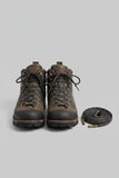 A coiled dark brown flat wax cotton shoelaces and boot laces with antique bronze metal tips on laces