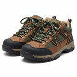 Pair of brown leather boots with green laces on a white background