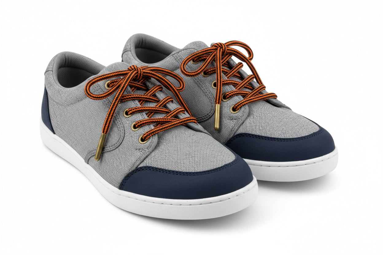 Pair of walking shoes with orange laces and black shoelaces and boot laces